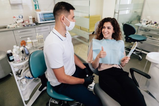 smiling-woman-approving-dental-work